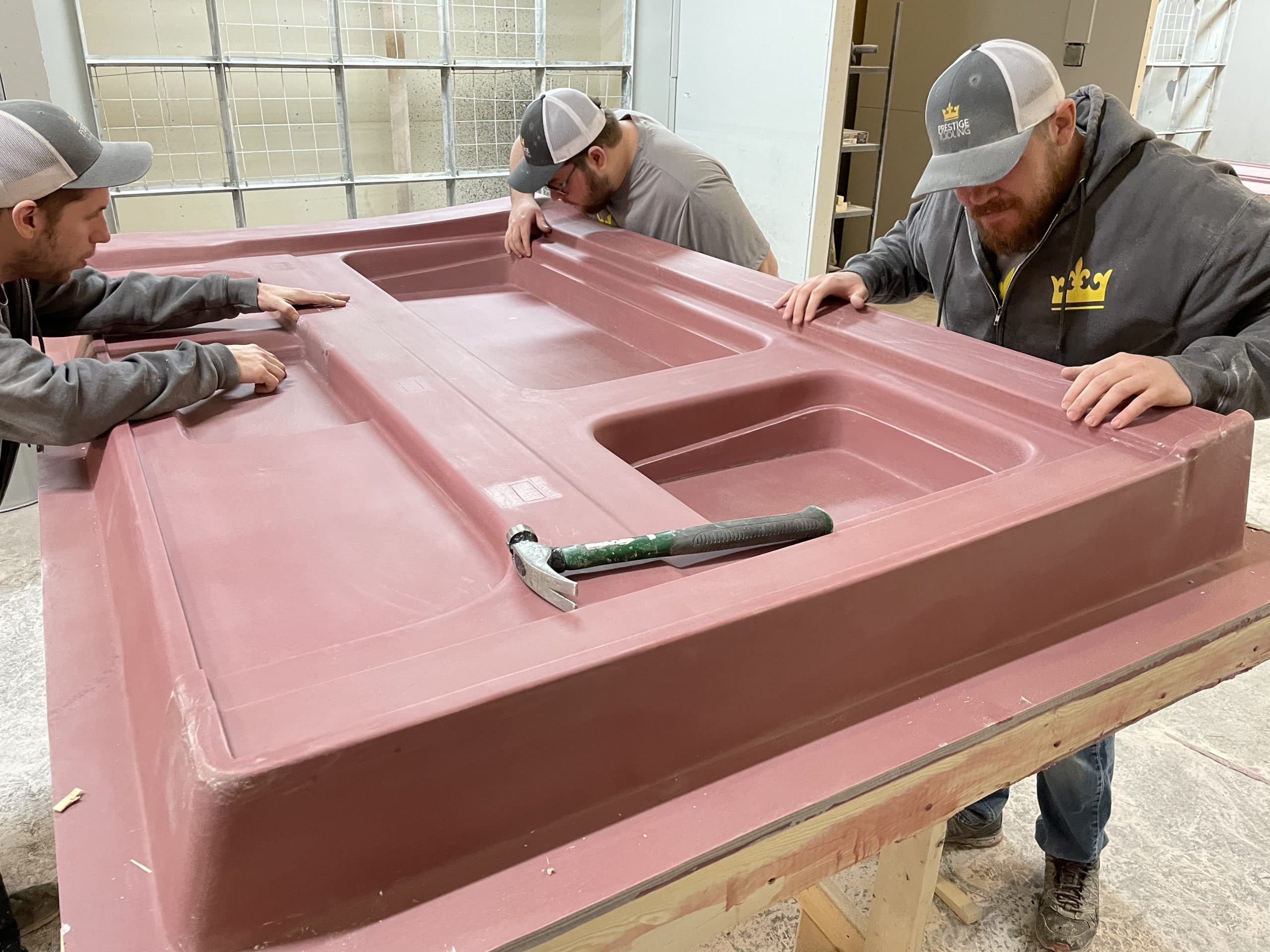 Three Prestige Tooling mold makers inspecting a large mold surface